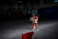 Young women boxes with donations of food distributed by an NGO to people suffering during the COVID-19 outbreak at the Cidade de Deus (City of God) favela in Rio de Janeiro, Brazil on April 7, 2020.