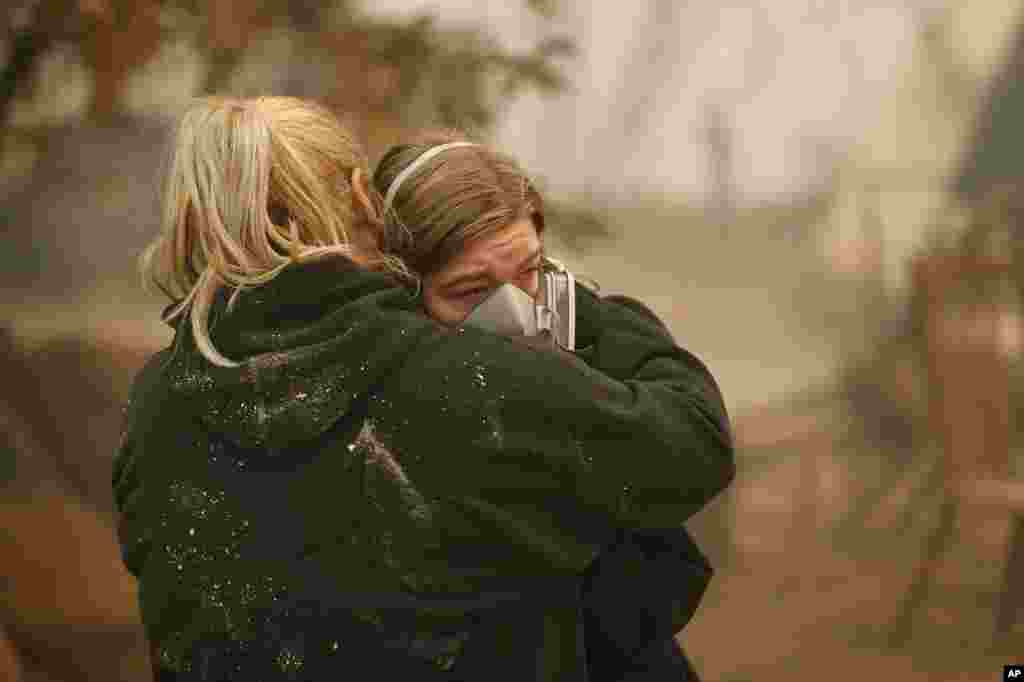 Krystin Harvey, left, comforts her daughter Araya Cipollini at the remains of their home burned in the Camp Fire, Nov. 10, 2018, in Paradise, Calif. 