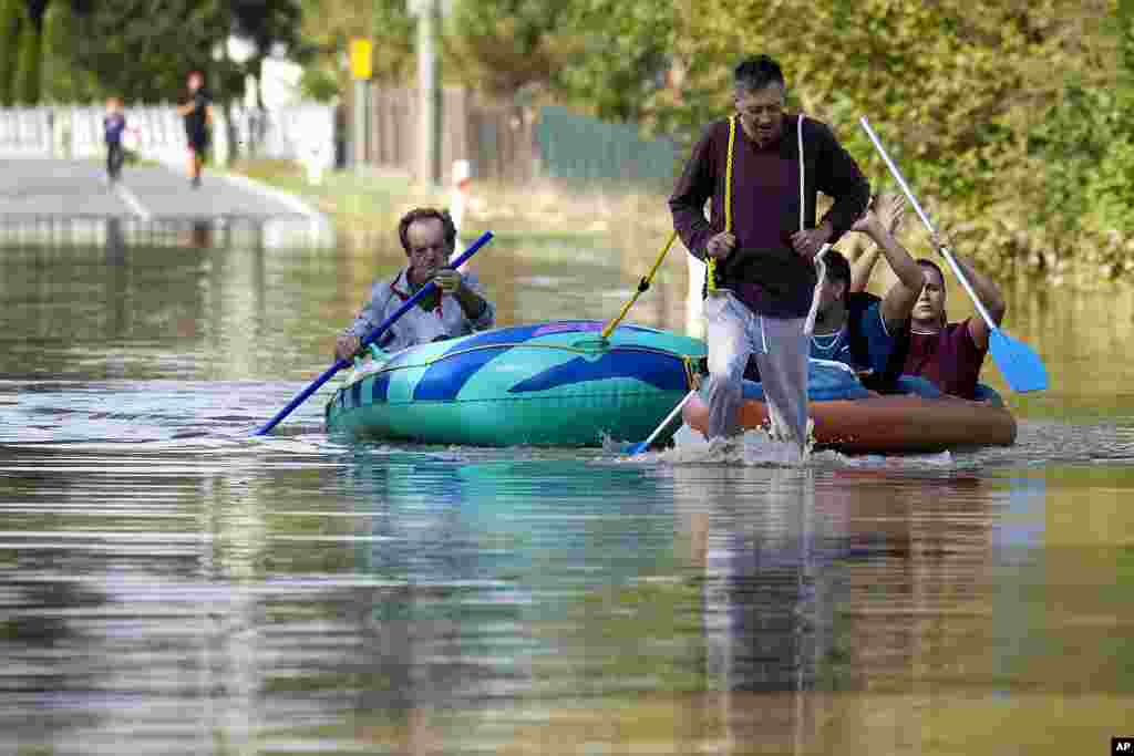 Warga mendayung perahu karet mereka melalui jalanan yang tergenang banjir di kota Bohumin, Republik Ceko. (AP)&nbsp;