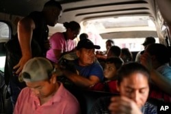 El migrante hondureño Luis Alonso Valle, en el centro, se sienta en una camioneta con su familia mientras esperan viajar a Tapachula desde Ciudad Hidalgo, México, después de cruzar el río Suchiate en una balsa, el 28 de octubre de 2024.