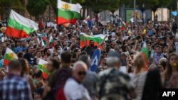 Protesters shout slogans and wave Bulgarian national flags during an anti-government protest in Sofia on July 11, 2020.