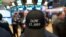 A stock trader wears a Dow 25,000 hat at the New York Stock Exchange, Jan. 4, 2018. 