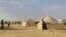 FILE - Syrians walk through the Ruqban refugee camp in Jordan's northeast border with Syria on June 22, 2016. Jordanian authorities announced Tuesday, Nov. 22, 2016, the resumption of aid to thousands of people, half of them children, who have been stuck with little food, water, medical care and other necessities since Jordan closed the border on June 21, 2016, to Syrian refugees.     