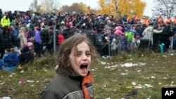 Une fille pleure, en tête des centaines de migrants qui tentent de traverser la frontière pour l'Autriche à partir de Sentilj, Slovenie, 29 octobre 2015. (AP Photo/Darko Bandic)