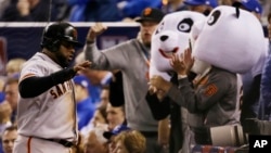 Pablo Sandoval es celebrado por dos aficionados con máscaras de Kung Fu Panda, el apodo con el que se le conoce, durante el séptimo juego de la Serie Mundial contra Kansas.