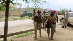 Afghan security personnel walk on a street in Kunduz, Afghanistan, Aug. 31, 2019, in a still image taken from video.