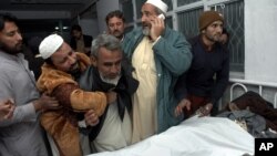 Pakistanis mourn next to the body of their relative killed in a suicide bombing, at a local hospital in Peshawar, Pakistan, Saturday, Dec. 22, 2012. 