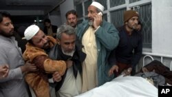 A Syrian man reacts as he carries the body of a boy following reported air strikes by government forces in the Halak neighbourhood in northeastern Aleppo.