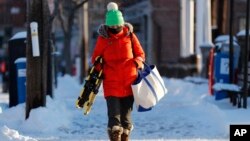 Lauren Webster is bundled up as she makes her way to work on a bitter cold morning, Jan. 31, 2019, in Portland, Maine.