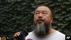 20일 휴대폰을 통해 변호사의 말을 전하는 중국 반체제 예술가 아이웨이웨이.