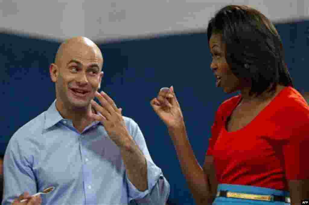 First lady Michelle Obama and Sam Kass assistant chef and Food Initiative Coordinator, taste food during a Let's Move event with members of Bravo's series "Top Chef" Friday, Feb. 10, 2012, at Kleberg Rylie Recreation Center in Dallas, during her three day