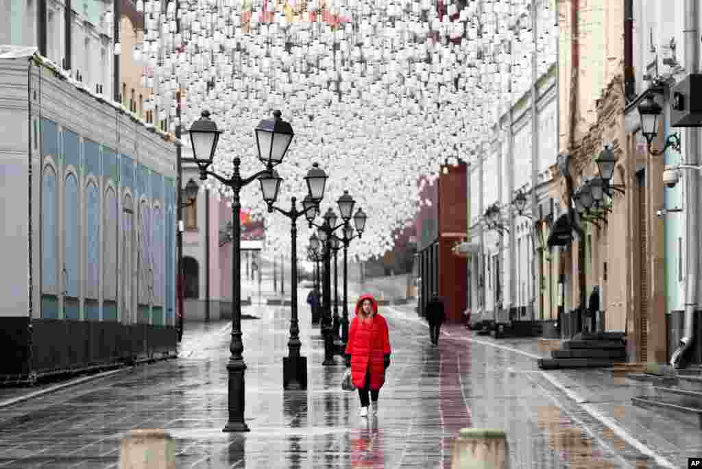 A woman walks through an almost empty pedestrian street in Moscow, Russia. President Vladimir Putin ordered most Russians to stay off work until the end of April as part of a partial economic shutdown to stymie the spread of the coronavirus.