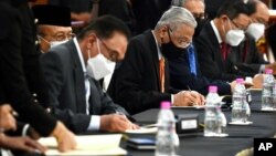 Pemimpin oposisi Malaysia Anwar Ibrahim (kiri) dan PM Ismail Sabri Yaakob menandatangani kesepakatan di gedung parlemen di Kuala Lumpur, Malaysia, Senin (13/9). 