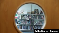 Ilustrasi. Buku-buku terlihat melalui jendela perpustakaan tertutup di Sekolah Dasar Watlington, Inggris, 21 Mei 2020. (Foto: Reuters/Eddie Keogh)