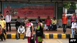 Commuters wait to board a Delhi Transport Corporation bus in New Delhi on October 29, 2019, following a Delhi government travel scheme distributing free bus tickets for women safety and empowerment.