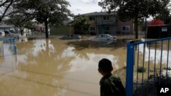 A boy looks onto flooded Nordale Avenue in San Jose, California, Feb. 22, 2017. Rising floodwaters sent thousands of residents fleeing inundated homes in San Jose and forced the shutdown of a major freeway.