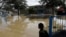 A boy looks onto flooded Nordale Avenue in San Jose, California, Feb. 22, 2017. Rising floodwaters sent thousands of residents fleeing inundated homes in San Jose and forced the shutdown of a major freeway.