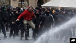 Water canon is used against demonstrators as they gather to protest against the COVID-19 restrictive measures at Old Town Square in Prague, Czech Republic, Oct. 18, 2020.