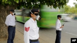 Policiers indiens portant des masques anti-pollution à New Delhi, en Inde, le 9 juin 2015.