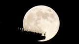 FILE - A supermoon rises behind an observation deck in New York City as seen from Hoboken, N.J., Friday, Nov. 15, 2024. (AP Photo/Seth Wenig)