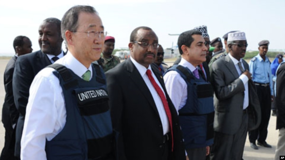 UN Secretary General, Ban Ki-moon (L) stands next to Somali Prime Minister Abdiweli Mohamed Ali (C Left) after his arrival at Mogadishu's Adan Abulle airport, December 9, 2011.