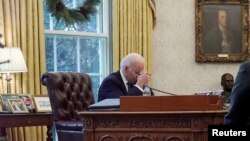 На фото: президент США Байден під час розмови з президентом України Володимиром Зеленським 9 грудня 2021. Фото було зроблено через шкляні двері.