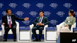 Cambodia's Prime Minister Hun Sen, left, gestures as he talks his vision on the Mekong region as Laos' Prime Minister Thongloun Sisoulith, center, and Myanmar State Counsellor Aung San Suu Kyi listen in the World Economic Forum on ASEAN at the National Convention Center Wednesday, Sept. 12, 2018, in Hanoi, Vietnam. The World Economic Forum has attracted hundreds of participants for the three-day forum with the theme: ASEAN 4.0: Entrepreneurship and the Fourth Industrial Revolution. (AP Photo/Bullit Marquez)