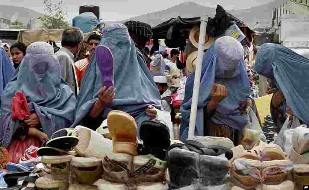 Afghan women shop in a busy Kabul market, on May 1, 2007. Despite advances in women's rights since the fall of the Taliban regime, most Afghan women, especially outside the capital, still opt to don the all-enveloping cloak known as the burqa. (AP) 