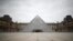 FILE - The area in front of the glass Pyramid of the Louvre museum in Paris is deserted as a lockdown is imposed to slow the rate of the coronavirus disease (COVID-19) in France, March 18, 2020.