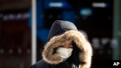 A woman, who declined to give her name, wears a mask in New York, Jan. 30, 2020.