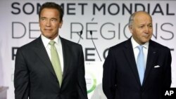 Former governor of California and founding chair of the R20 initiative, Arnold Schwarzenegger, left, and France's Foreign Minister Laurent Fabius, stand prior to making a speech at the World Summit of Regions for Climate, in Paris, Oct. 11, 2014.