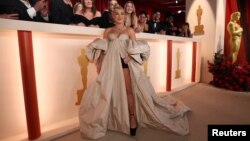 Florence Pugh poses on the champagne-colored red carpet during the Oscars arrivals at the 95th Academy Awards in Hollywood, Los Angeles, California, March 12, 2023.
