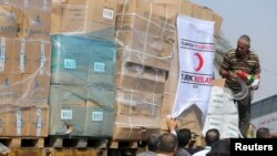 Palestinians unload Turkish aid shipments upon arrival in the Gaza Strip at Kerem Shalom crossing between Israel and southern Gaza Strip, July 4, 2016. 