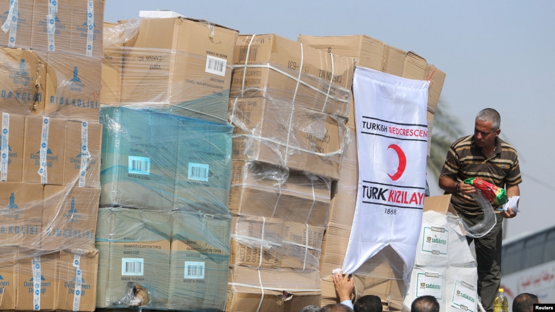 Warga Palestina menurunkan bantuan kemanusiaan asal Turki setibanya di Jalur Gaza yaitu di Kerem Shalom, sebuah perlintasan antara Israel dan sisi selatan Jalur Gaza. (Foto: REUTERS/Ibraheem Abu Mustafa)