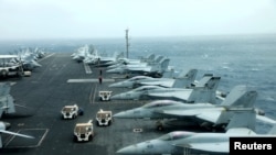 FILE - F/A-18F aircrafts are seen on the deck of USS Abraham Lincoln in the Gulf of Oman near the Strait of Hormuz, July 15, 2019. 