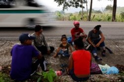 FILE - Four-year-old Arony Maude from Honduras rests next to her uncle Edgar Omar, also from Honduras, and the rest of her family along a motorway, on their way to the United States, in El Ceibo, Tabasco, Mexico, March 26, 2021