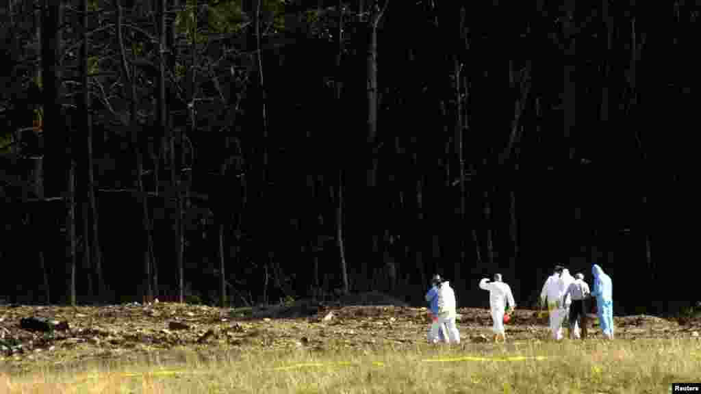 Des enquêteurs fouillent un champ de débris, sur le lieu où un avion commercial s&rsquo;est écrasé près de Shanksville, en Pennsylvanie, 11 septembre 2001.