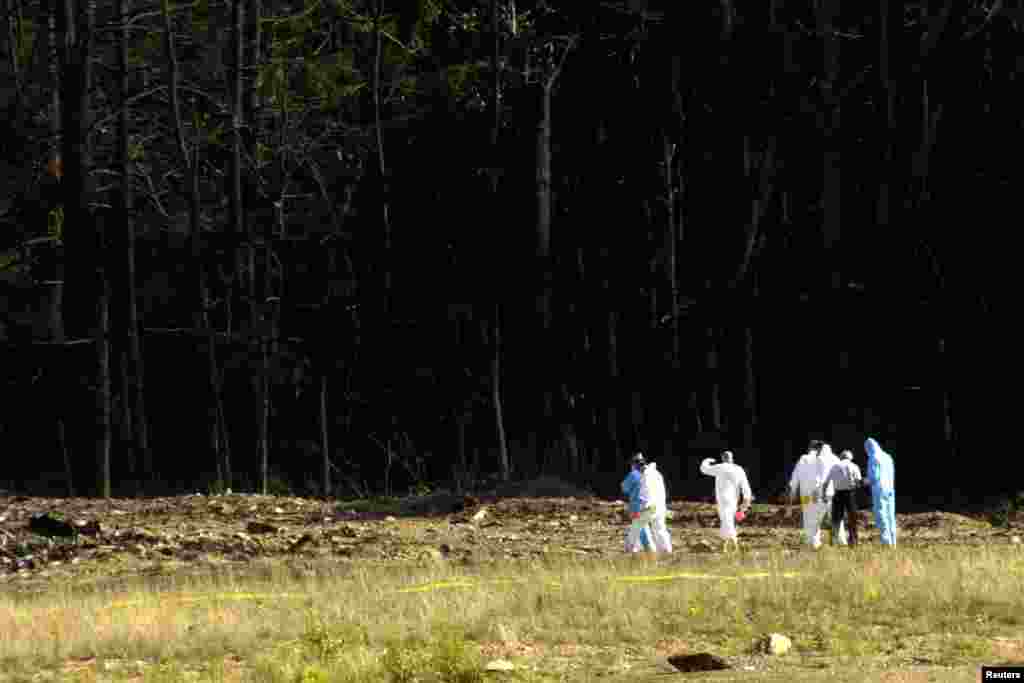 Investigators head into the debris field at the site of a commercial plane crash near Shanksville, Pennsylvania. The crash is one of four planes that were hijacked as part of a deadly and destructive terrorist plot.