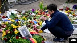 FILE — A woman lights a candle at a makeshift memorial of flowers and candles for Russian opposition leader Alexei Navalny in front of the Russian embassy in Berlin on March 1, 2024, the day of Navalny's funeral in Russia.