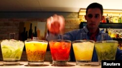 FILE - A barman prepares caipirinhas, Brazil's national cocktail, made with cachaca (sugar cane hard liquor), sugar and lemon or another fruit.
