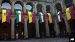 FILE - Mexican and Ecuadoran flags hang at the National Palace in Mexico City, Nov. 24, 2022. Mexican President Andres Manuel Lopez Obrador broke diplomatic ties with Ecuador on April 5, 2024, after Ecuadoran police broke into the Mexican Embassy in Quito.