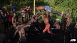 FILE—A young fighter is lifted as members of Uganda's Soft Ground Wrestling battle during a training session at their camp in Mukono on February 28, 2024.