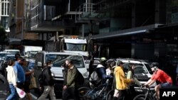 People cross a traffic intersection in the central business district of Sydney, Australia, June 18, 2020.