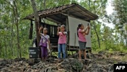 Tiga orang murid SD yang sedang menjalankan tugas Pembelajaran Jarak Jauh (PJJ) berusaha mencari sinyal dengan ponsel mereka di Desa Bukit Temulawak, Gunung Kidul, Yogyakarta (foto: dok). 