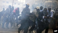 Manifestants antigouvernementaux fuyant des tirs de gaz lacrymogène à Dakar, le 15 février 2012