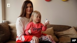 Victoria Mickleburgh and her daughter Grace pose for photographs at their home in Cobham on the outskirts of southwest London, Jan. 23, 2019. 