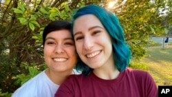 This August 15, 2022, photo shows El Johnson, right, with her girlfriend, Sara Goodie, in Austin, Texas. Johnson has decided not to bear children, though she hasn’t ruled out adoption. (El Johnson via AP)