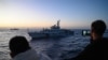 FILE - Personel Penjaga Pantai Filipina merekam kapal Penjaga Pantai China selama misi pasokan di Laut Cina Selatan yang disengketakan, 5 Maret 2024. (JAM STA ROSA / AFP)