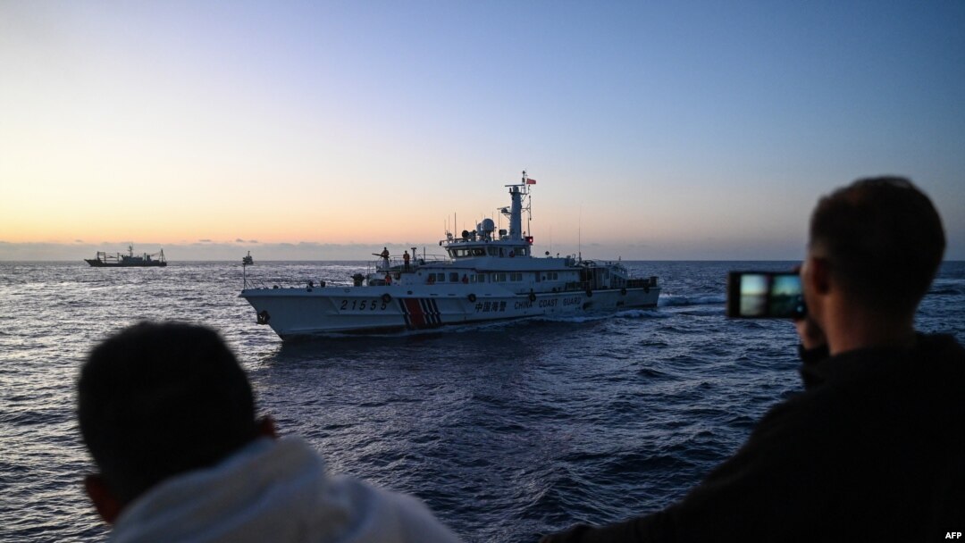 Personel Garda Pantai Filipina merekam kapal Garda Pantai China di Laut China Selatan yang disengketakan. (Foto: AFP)