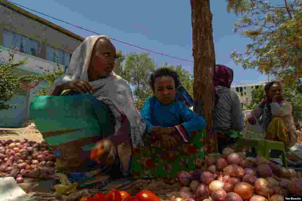 A woman tries to sell tomatoes and onions on an almost empty market in Hawzen, Ethiopia, on June 6, 2021. (VOA/Yan Boechat)